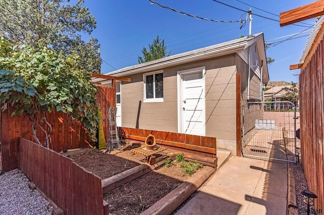 view of outbuilding with fence and a gate