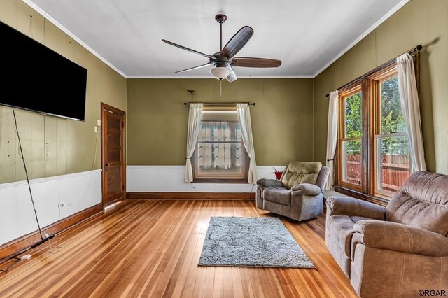 unfurnished room with light wood finished floors, ceiling fan, and ornamental molding