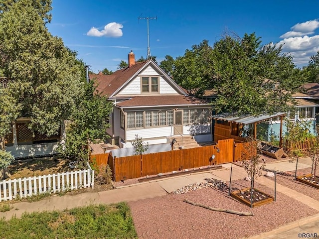 view of front of property featuring a fenced front yard, a chimney, and a gate