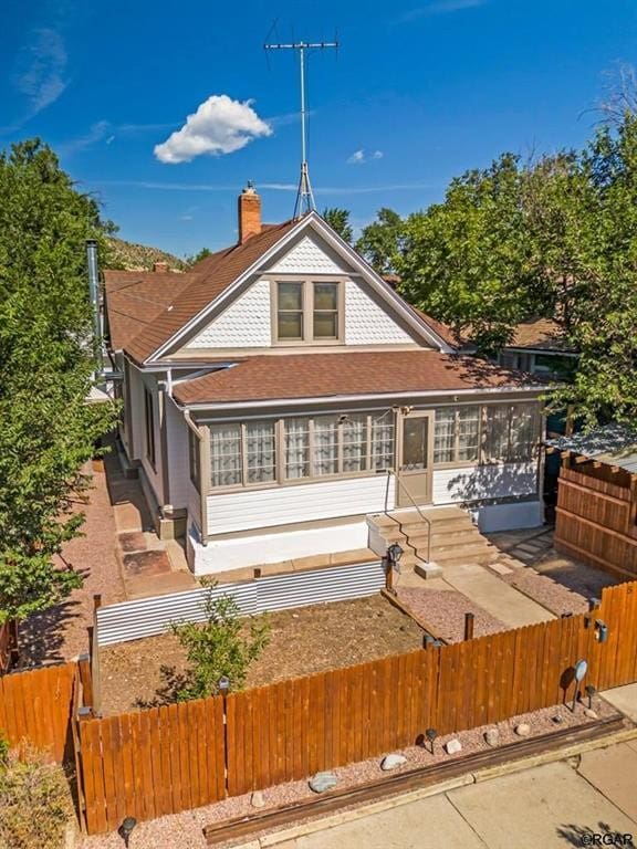 back of property featuring a fenced front yard and a chimney