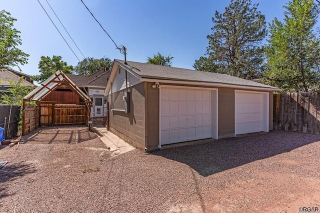 detached garage featuring fence