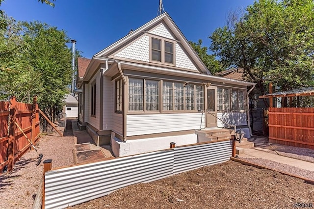 back of property with entry steps and fence