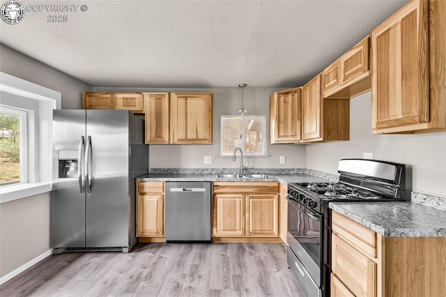 20 N Wilmont Cir, Williamsburg, CO 81226 - kitchen with stainless steel appliances, a sink, light wood finished floors, light brown cabinets, and a textured ceiling