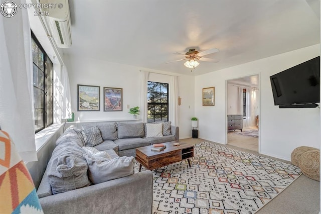 living room featuring ceiling fan, light colored carpet, and baseboards