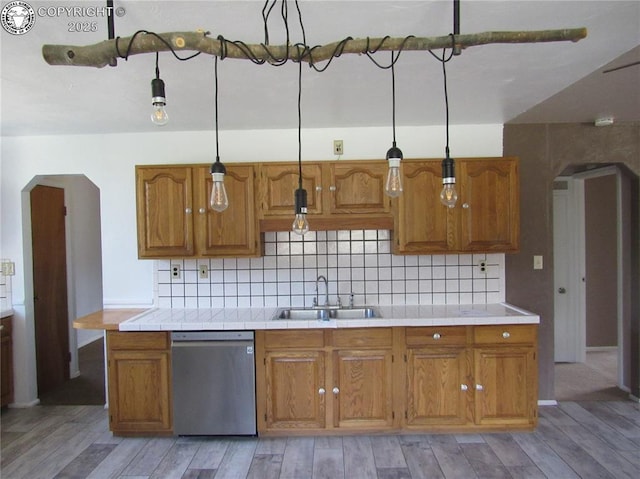 855 Ernest Ave, Westcliffe, CO 81252 - kitchen with dishwasher, arched walkways, brown cabinets, and decorative backsplash