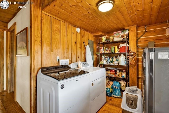 laundry room with wood ceiling, wood-type flooring, wooden walls, and washing machine and clothes dryer