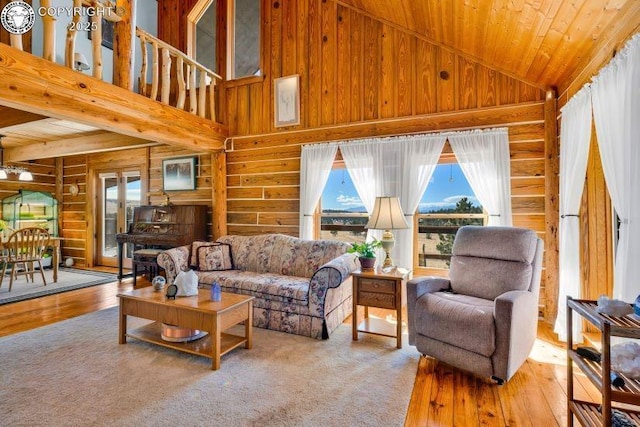 living room with wood-type flooring, wooden ceiling, high vaulted ceiling, and wood walls