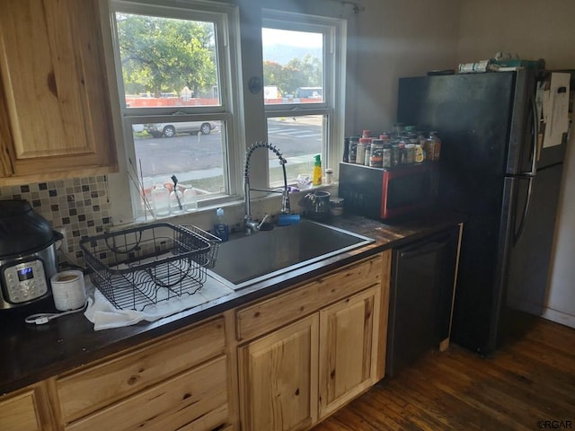 kitchen featuring sink, backsplash, fridge, black dishwasher, and dark hardwood / wood-style flooring