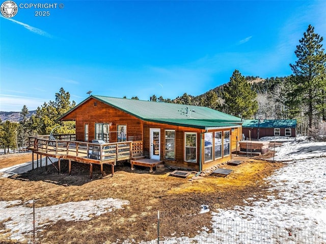 back of property with a wooden deck and metal roof