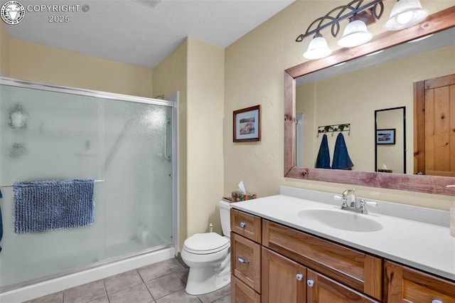 bathroom featuring tile patterned floors, toilet, a stall shower, and vanity