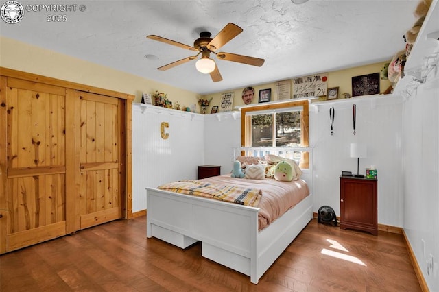 bedroom featuring a textured ceiling, a ceiling fan, and wood finished floors