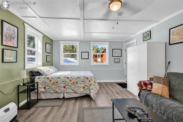 bedroom with baseboards, wood finished floors, and ornamental molding