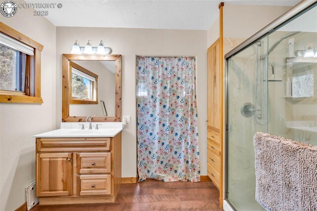 bathroom with a shower stall and vanity