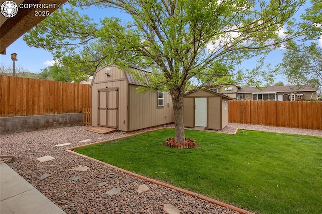 view of yard featuring a fenced backyard, an outbuilding, and a storage shed