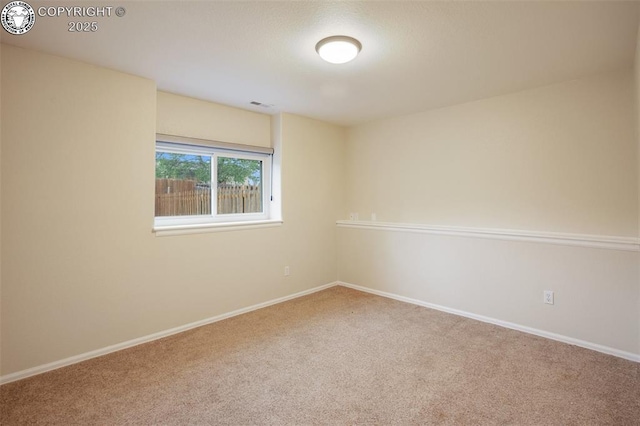 carpeted spare room featuring baseboards and visible vents