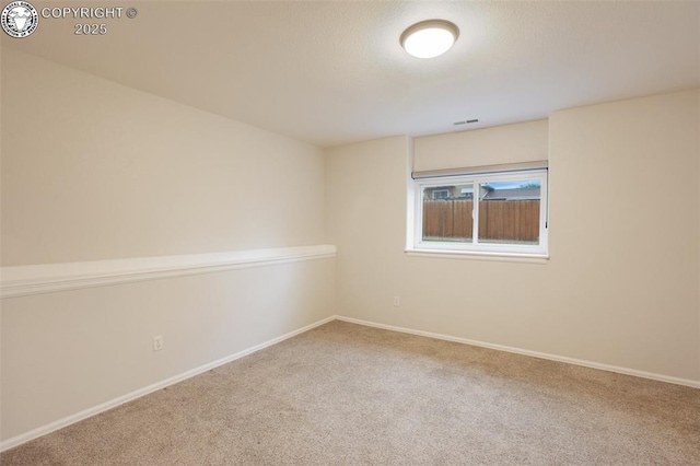 carpeted spare room with baseboards and visible vents