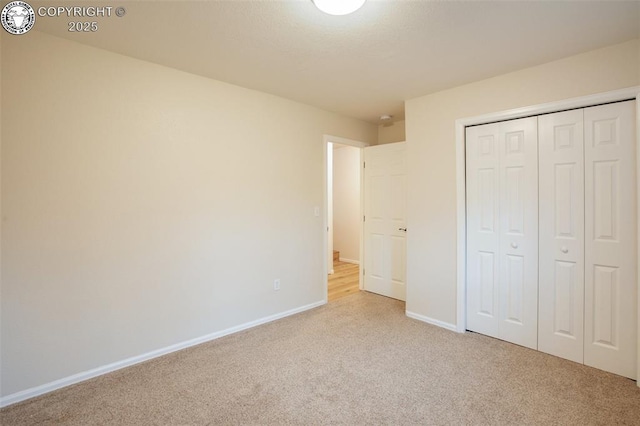 unfurnished bedroom with carpet floors, baseboards, and a closet
