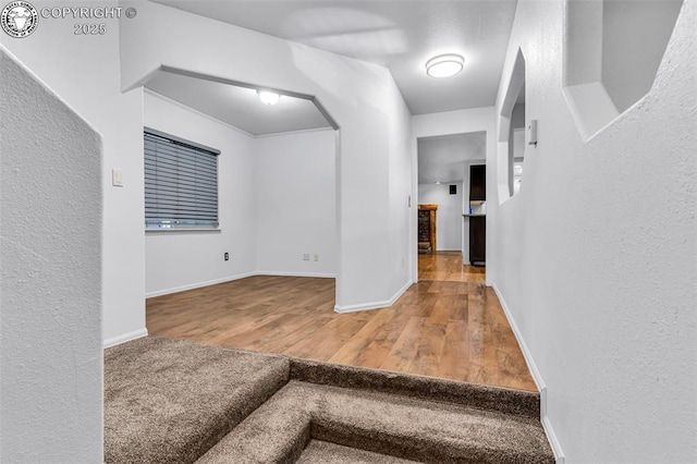 855 5th St, Penrose, CO 81240 - corridor featuring wood finished floors, baseboards, arched walkways, and a textured wall