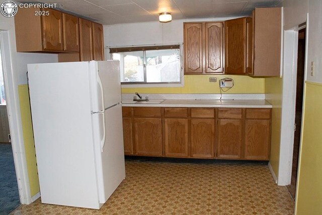 485 Spring Ave, Rockvale, CO 81244 - kitchen with freestanding refrigerator, light countertops, and brown cabinets