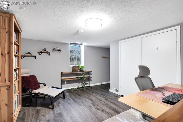 home office featuring a textured ceiling and dark hardwood / wood-style flooring