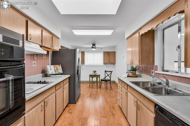 1035 Ohio Ave, Canon City, CO 81212 - kitchen with black appliances, under cabinet range hood, decorative backsplash, and light countertops