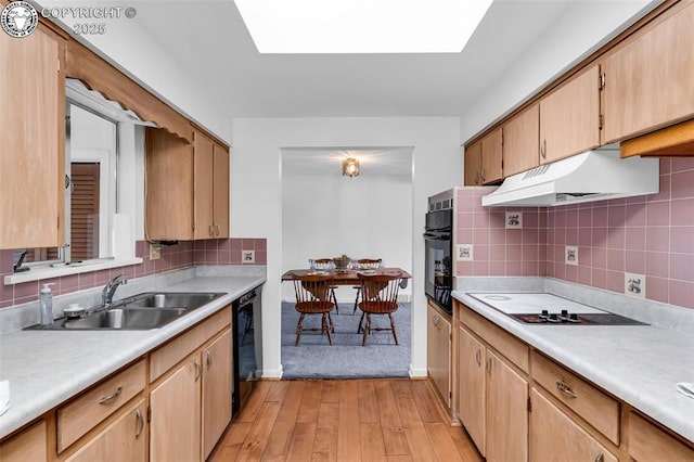 1035 Ohio Ave, Canon City, CO 81212 - kitchen with black appliances, under cabinet range hood, light wood finished floors, light countertops, and backsplash
