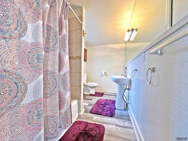 full bathroom featuring shower / tub combo, hardwood / wood-style floors, sink, and toilet