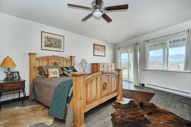 bedroom featuring a baseboard radiator, dark wood-type flooring, access to outside, and ceiling fan