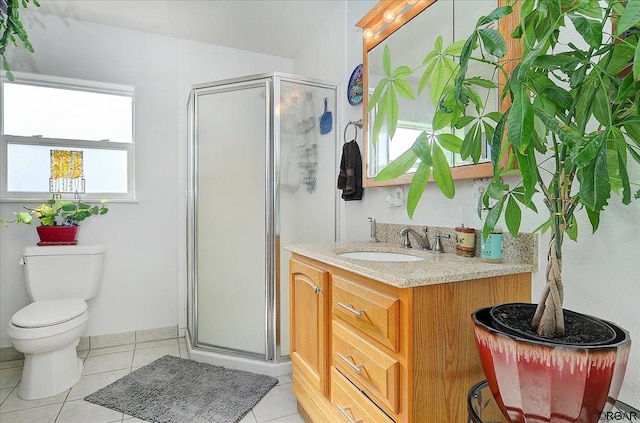 bathroom featuring vanity, tile patterned floors, toilet, and walk in shower