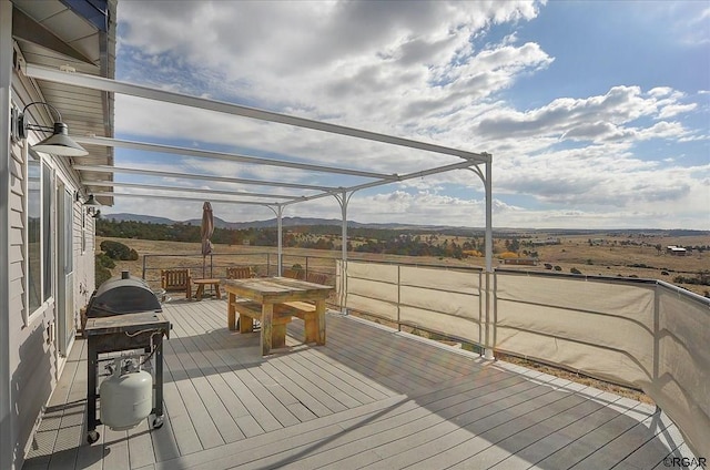 wooden deck featuring grilling area, a pergola, and a rural view