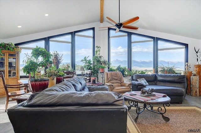 living room featuring ceiling fan, a mountain view, and vaulted ceiling with beams