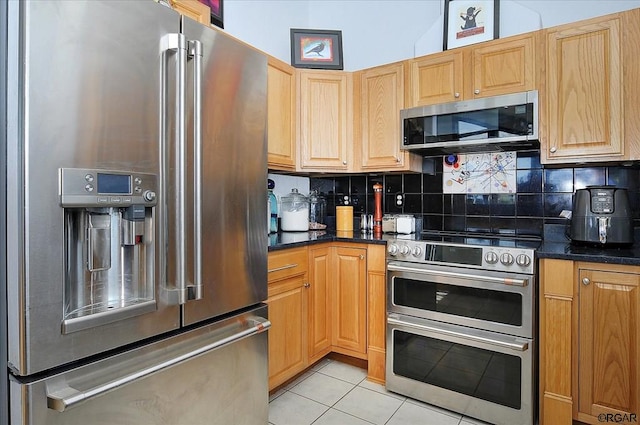 kitchen featuring stainless steel appliances, decorative backsplash, and light tile patterned floors