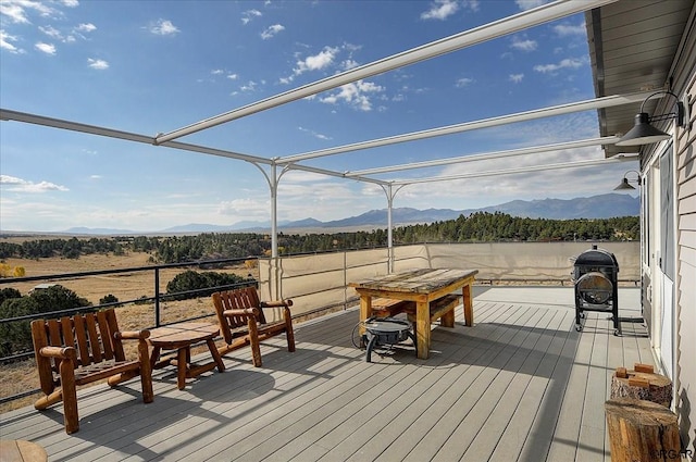 deck featuring a mountain view, a grill, and a pergola