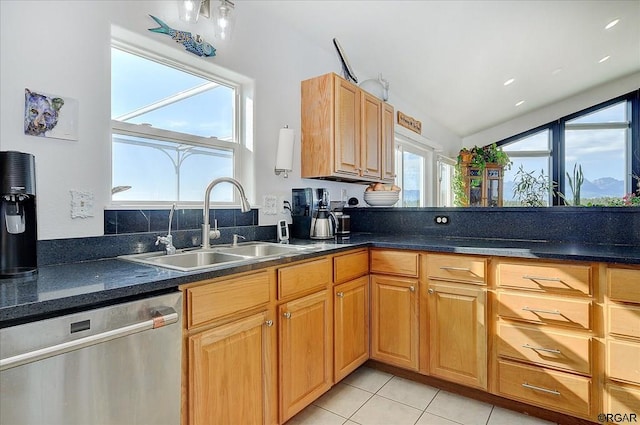 kitchen featuring light tile patterned floors, dishwasher, sink, and a wealth of natural light