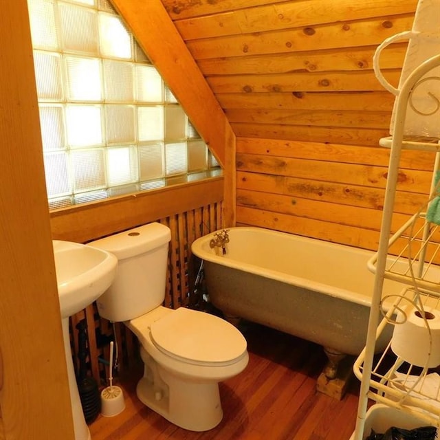 bathroom with rustic walls, hardwood / wood-style flooring, a washtub, wood ceiling, and toilet