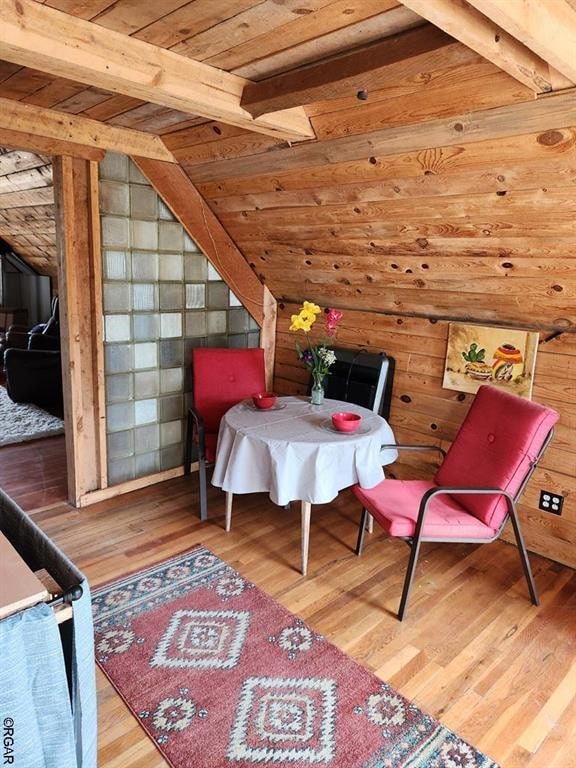 interior space featuring vaulted ceiling with beams, wood ceiling, and light wood-type flooring