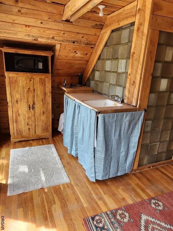 interior space with wooden ceiling, sink, light hardwood / wood-style flooring, and vaulted ceiling with beams