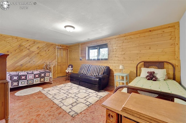 bedroom featuring a textured ceiling and wood walls