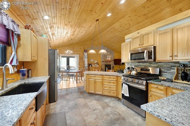 kitchen with light brown cabinetry, stainless steel appliances, a peninsula, decorative backsplash, and vaulted ceiling