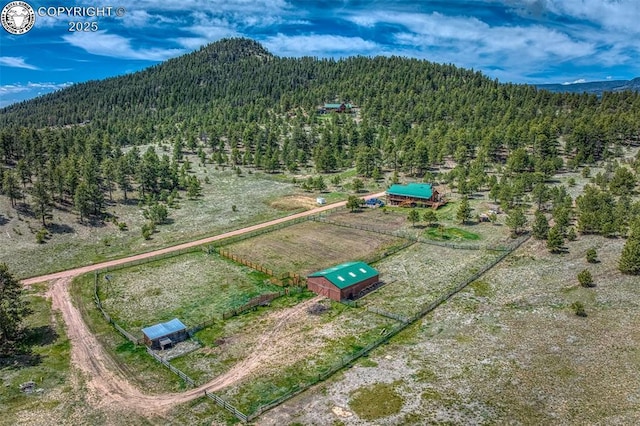 aerial view with a rural view, a view of trees, and a mountain view