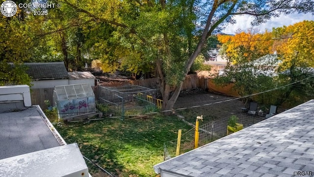 view of yard with an exterior structure, a fenced backyard, and an outdoor structure