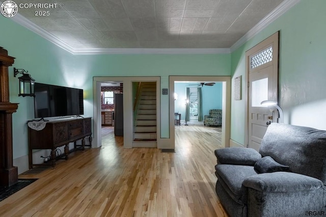 living room with light wood-style floors and crown molding