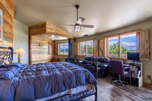 bedroom featuring wooden walls, dark hardwood / wood-style floors, ceiling fan, and vaulted ceiling