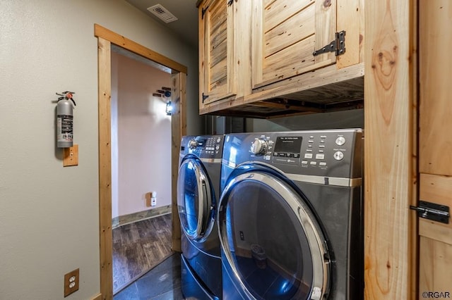 washroom featuring cabinets and washing machine and dryer