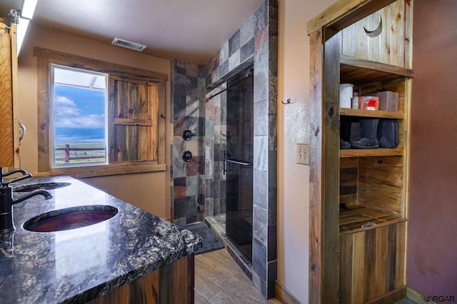 bathroom with vanity, hardwood / wood-style flooring, and a shower with shower door