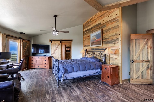 bedroom with wood walls, lofted ceiling with beams, dark hardwood / wood-style flooring, ceiling fan, and a barn door