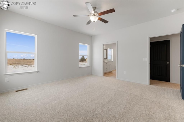 unfurnished bedroom featuring connected bathroom and light carpet