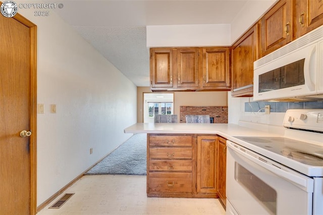 1108 Fairview Ave Unit B, Canon City, CO 81212 - kitchen featuring white appliances, brown cabinetry, a peninsula, light countertops, and decorative backsplash