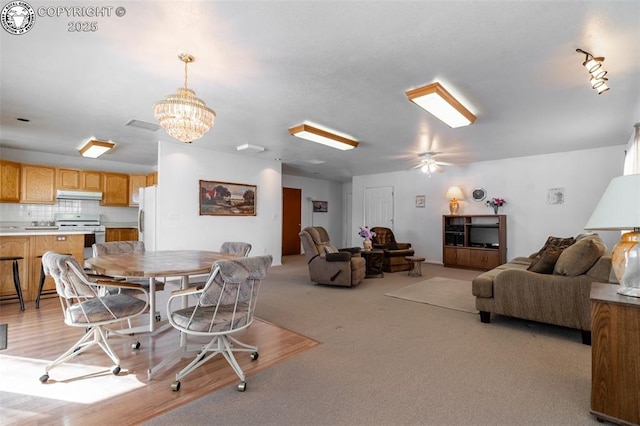 dining space featuring light colored carpet and an inviting chandelier