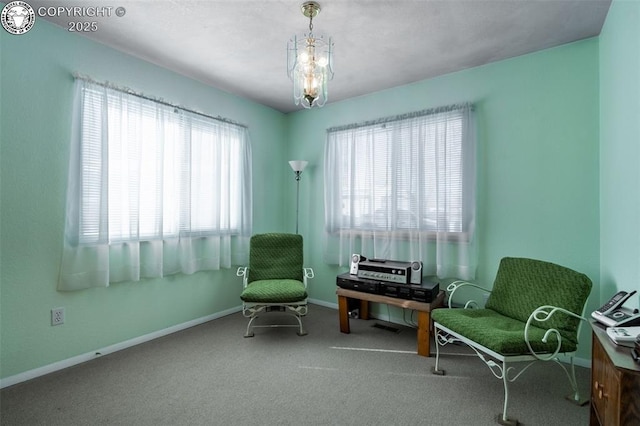 living area featuring an inviting chandelier and carpet floors